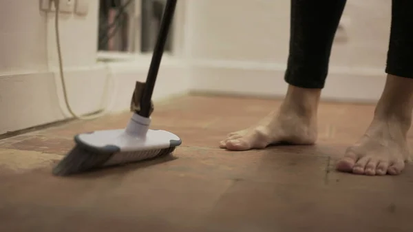 Person sweeping very dirty floor doing housework
