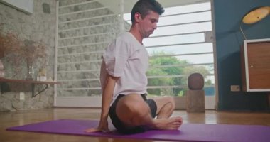 Flexible man stretching at home floor. Person stretches body in living room