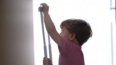 Child playing with luggage handle. One little boy preparing to travel with suitcase travel for trip