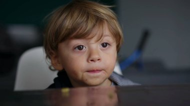 Bebek bebek ekranda hipnotize edildi, çocuk çizgi film izlerken masayı ısırdı.