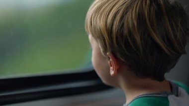 Passenger child traveling by train entering tunnel. One small boy by window on high speed transportation