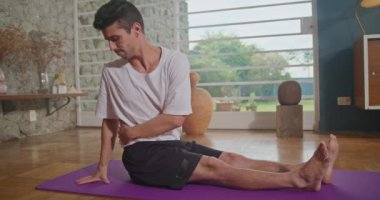 Flexible man stretching at home floor. Person stretches body in living room