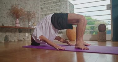 Flexible man stretching at home floor. Person stretches body in living room