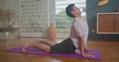 Flexible man stretching at home floor. Person stretches body in living room
