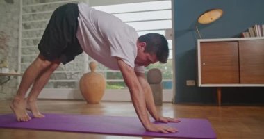 Flexible man stretching at home floor. Person stretches body in living room