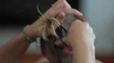 Hand closeup tying child hair. Tie hair