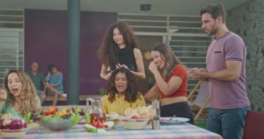 Group of hispanic diverse group of people standing at barbecue party together. Friends enjoying life together during sunny day outdoors