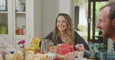 Joyful family at breakfast table. Older senior couple smiling together with daughter