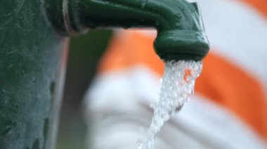 Kid washing feet at water faucet outside. Child cleaning body foot outdoors at park