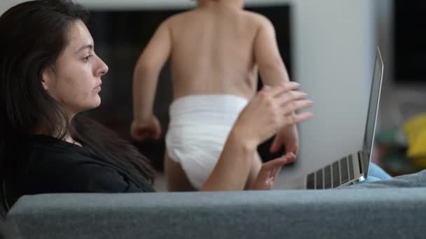 Woman Working Home Using Laptop Child Jumping Sofa Parent Front — Vídeo de Stock