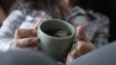 Elinde çay fincanı tutan kadın. Kadın eli sıcak bir içecek tutuyor.