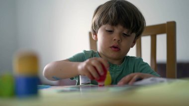 Çocuk evde yaratıcılık aktivitesi boyuyor. Sanatçı çocuk resim yapıyor.