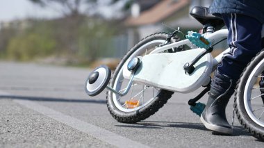 Dışarıda bisikletten düşen çocuk ayakları. Çocuk bisiklet sürmeyi öğreniyor. Deneme yanılma konsepti