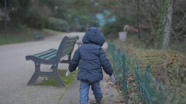 Child walking outside at park during winter time