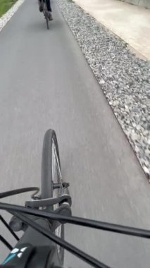 Bicycle wheel on aspahlt in motion. Person POV riding bike