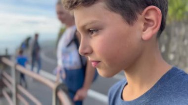 Profile of handsome child standing outside in contemplation. Pensive kid closeup face