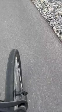 Bicycle wheel on aspahlt in motion. Person POV riding bike