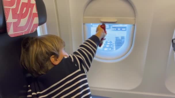 Small Passenger Boy Seated Airplane Opening Window Waiting Departure Mischievous — Wideo stockowe