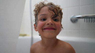 Çocukları içeride yıkıyorlar. Küçük kardeşle banyo yapan genç bir çocuk.