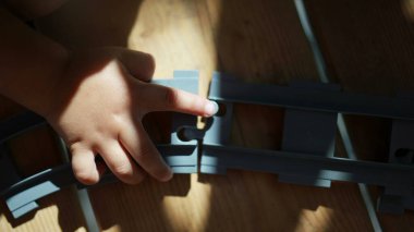 Çocuk eli demiryolu parçalarını birleştiriyor