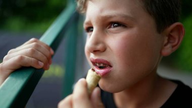 Seyirci çocuk dondurma yerken maç seyrediyor. Oyun tarafından hipnotize edilen çocuk