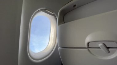 Airplane window during flight. Passenger POV staring at tray table inside plane cabin