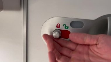 Opening airplane bathroom door lavatory. Passenger POV opens door