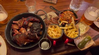 Tasty food dinner plate at restaurant. Meat fries beer and appetizers unhealthy food BBQ