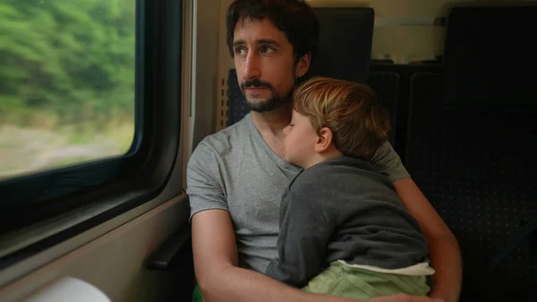 Father holding sleep baby traveling by train, dad holding toddler asleep on transportation