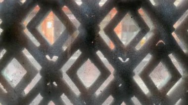 Dirty old glass with patterns with city street in background. Grungy shot concept