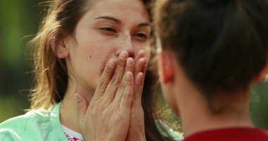 Candid young woman adjusting hair and rubbing face with hand
