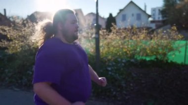 One overweight man starts to run outside getting back to into shape. Male big caucasian person running outdoors exercising body. Motivational discipline concept.