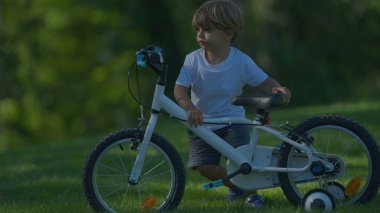 Bisikletli çocuk tepeye çıkamıyor.