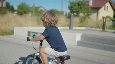 Bisiklet süren aktif küçük bir çocuk Çocuk bisikleti sürüyor