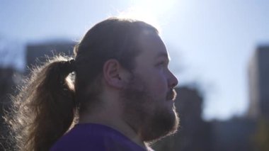 One calm serene person opening eyes to sky smiling. One meditative overweight male person close up tracking shot