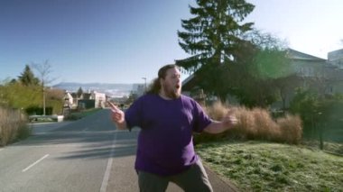 One happy overweight man dancing outside in street. A fat Person celebrating good news bouncing with joy