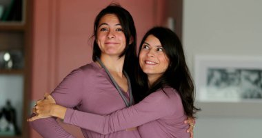 İki yetişkin kız kardeş birbirine sarılıyor. Aile sevgisi ve sevgisi.