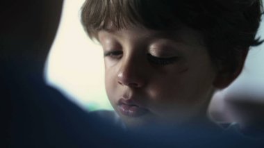 İçten, ağlayan, düşünceli, yakın çekim suratlı bir çocuk. Üzgün ve düşünceli bir çocuk.