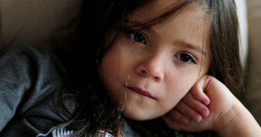 Sevimli küçük kız yüzü kanepede uzanıp eğlencesini izliyor.