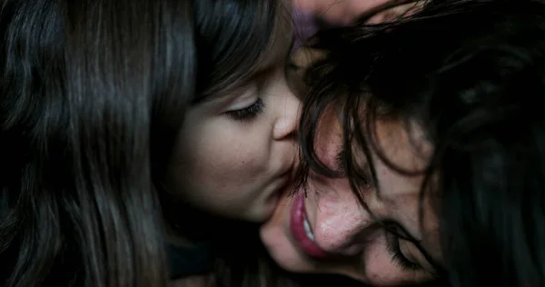 Mother kissing daughter family love and affection