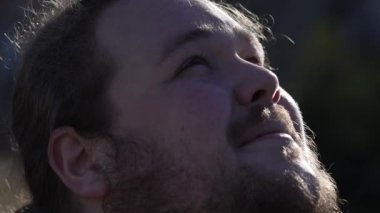 Contemplative thoughtful man standing outside smiling feeling spiritual