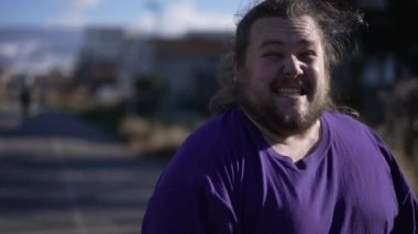Person celebrating success feeling ecstatic standing outside. Happy emotion close up face. Tracking shot of One overweight joful male person. Triumph concept