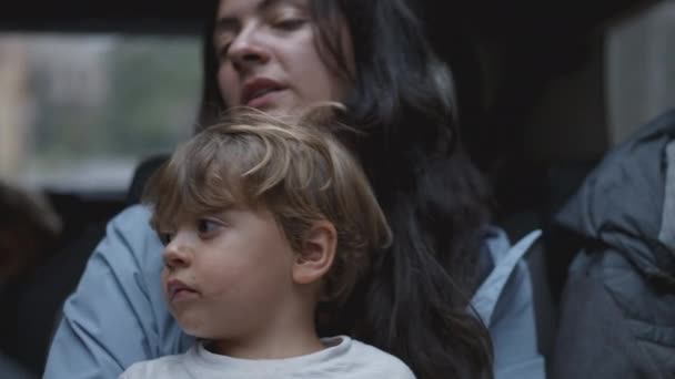一个小男孩在妈妈的怀里坐在汽车后座上 在车内行走的儿童 — 图库视频影像