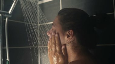 Duş banyosunda yüzünü yıkayan kadın. Kadın günlük hijyen rutini