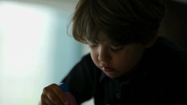 Odaklanmış çocuk boyama aktivitesi yakın çekim yüzü. Küçük çocuk okul ödevi yapıyor.