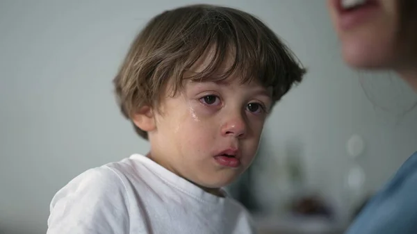 Portrait of a tearful child crying. Closeup face of a sad little boy. Authentic real life kid cries. Lifestyle sobbing moment