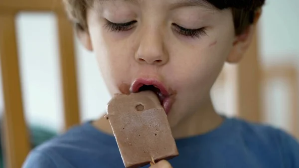 Child mouth covered with chocolate icecream. Little boy taking a bite of ice cream sweet dessert