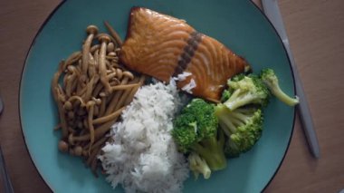 Plate of salmon with rice broccoli and shimeji. Top view of healthy Food meal