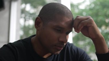 Preoccupied man with worried expression. A pensive African American person thinking about solution