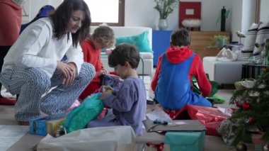 Children receiving presents in the morning during Christmas day. Family unboxing gifts